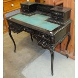 A late-Victorian ebonised writing table, the rectangular top with low back, fitted with four smal