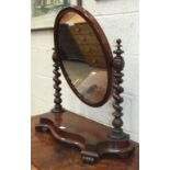 A Victorian mahogany dressing table mirror with oval plate, spiral column supports and serpentine