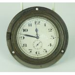 An early-20th century metal dashboard eight-day clock, the silvered dial with seconds subsidiary,