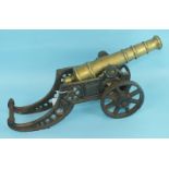 An early-20th century bronze cannon on cast iron wheeled carriage, 38cm long, the barrel 28cm long.