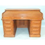 A large oak Angus roll-top office desk, the shallow top with tambour enclosing an arrangement of