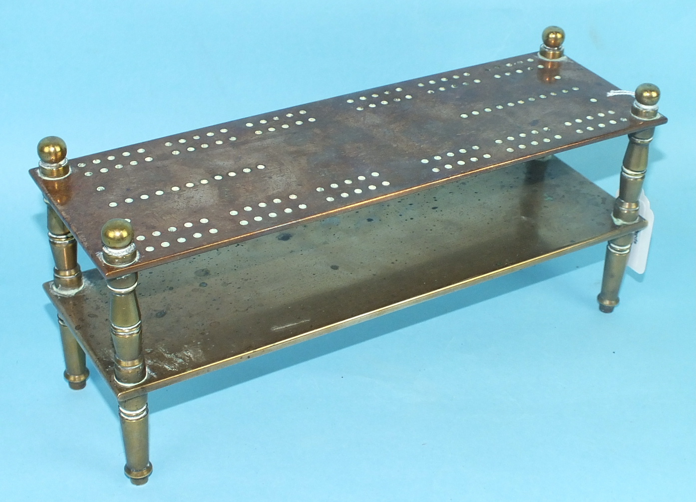 A bronze and brass cribbage board, the two rectangular tiers on turned legs, 28cm long, 13cm high,
