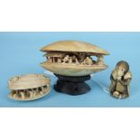 A Japanese ivory okimono of a seated monkey eating fruit and two Japanese ivory clam carvings,
