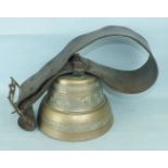 A Continental bronze cow bell with leather strap and iron buckle, 25cm diameter, 18cm high.