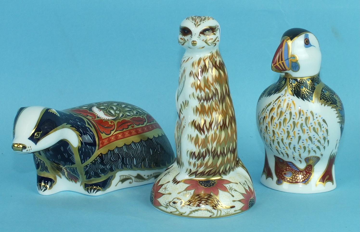 A collection of three Crown Derby animal paperweights, 'Moonlight Badger' (gold), 'Meercat' (