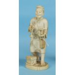 A Japanese ivory figure of a man selling food, signed, 16.5cm.