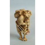 A fine Japanese ivory and inlaid okimono of a demon carrying a bag inlaid with mother-of-pearl and