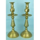 A pair of 20th century brass altar table candlesticks, each with sconce and intermediate drip pan,