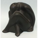 A modern Lalique black glass figure of a seated nude, head resting between crossed legs, 6cm high,