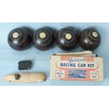 A set of four bowling bowls and a partially-made Modelcraft 3L Mercedes-Benz racing car kit.