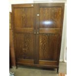 A mid-20th century gent's solid oak fitted two-door wardrobe on base, 122cm wide, 183cm high and a