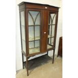 An Edwardian inlaid mahogany display cabinet, the shaped rectangular top above a pair of glazed