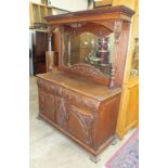 A 19th century carved oak sideboard, the mirrored back above two frieze drawers and two panelled