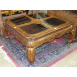 A modern Oriental hardwood coffee table inset with four glass panels, 112 x 107cm.