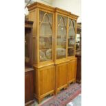 A modern craftsman-made light oak bookcase, the cornice above three glazed doors, three slides and