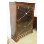 A mid-20th century mahogany low bookcase, the rectangular top above a single-glazed door, on base,