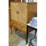 A mid-20th century walnut cupboard, the rectangular top above a pair of doors and frieze drawer,