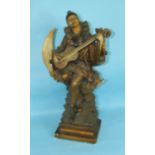 An Art-Nouveau-style plaster figure of Pierrot seated on a moon, playing the mandolin, 63cm high.