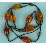 Eight yellow and light brown amber beads, (one af), on cord with metal and glass beads, total weight