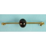 A 9ct gold bar brooch set a garnet cabochon, 6.6g.