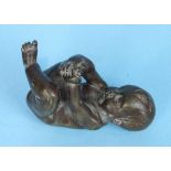 An early-mid 20th century cast bronze figure of a baby boy lying on his back, clasping his right