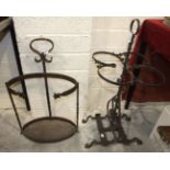 A wrought iron umbrella stand with oval base, 66cm high and a four-division metal stand, (2).