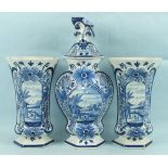 A garniture of three 19th century Dutch Delft blue and white vases and a cover, tallest 35cm, (3).