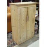 A stripped pine two-door cupboard, 66cm wide, 108cm high.