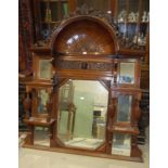 A late-Victorian/Edwardian large walnut over-mantel mirror, the concave cornice with carved cresting