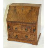 A 20th century miniature replica of a walnut bureau, 27cm high, 23cm wide.