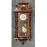 A late-19th century walnut-cased Vienna-style wall clock with cornice and pressed brass dial, gong-