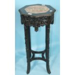 A Chinese hardwood octagonal urn stand, the top inset with pink marble, on bamboo-carved legs,