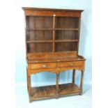 A small Georgian oak dresser, the plate rack above two frieze drawers, on turned front legs joined