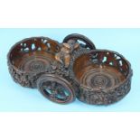 An unusual early-19th century walnut double bottle wagon, the two pierced coasters carved with vines