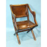 An antique mahogany X-framed hall chair with panelled back and seat.