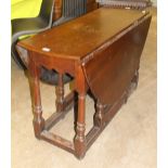 An antique oak drop-leaf dining table, the oval top above an end drawer, on turned legs joined by