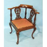 A Georgian-style corner chair with curved back and pierced splats, on cabriole legs.