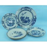 An 18th century Chinese blue and white dish decorated with objects on a rock with flowering shrubs
