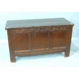 An antique oak coffer, the hinged lid with panel body, stiles extended to form feet, 130cm wide,