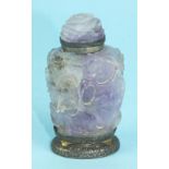 An early-20th century table lighter in the form of an Oriental carved amethyst snuff bottle, the