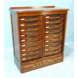 A mahogany nest of eighteen filing drawers, each with gilt-lettered titles for stationery and filing