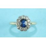 A sapphire and diamond cluster ring set an oval sapphire, within a border of eleven 8/8-cut