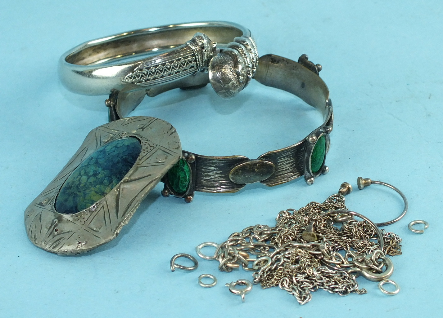 A Ruskin-style enamel and white metal brooch, a plated metal bracelet with green enamel plaques, a