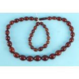 A necklace and matching bracelet of cherry amber Bakelite beads.