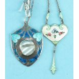 An Art Nouveau silver pendant of shield shape set blister pearl between blue enamelled hearts, maker