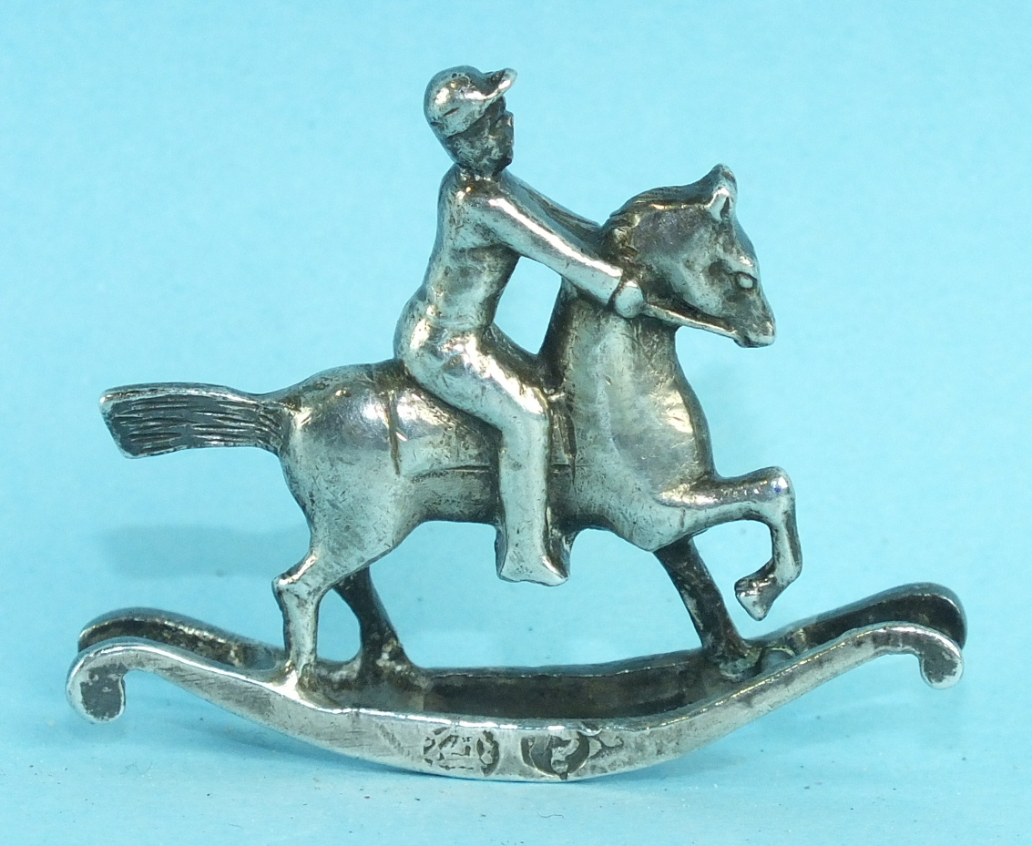 A small silver model of a rocking horse and rider, some marks rubbed, London import marks for