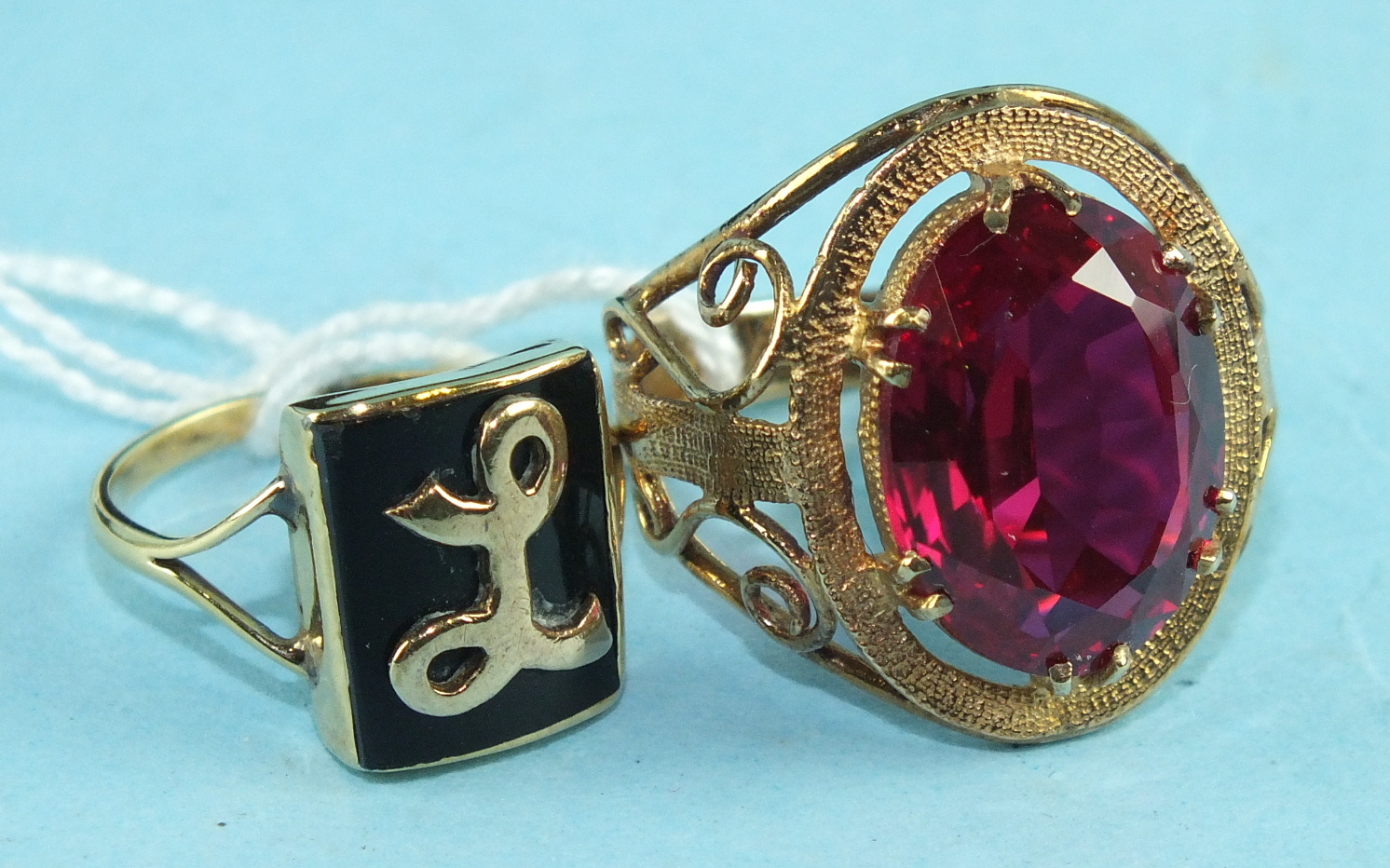 A 9ct gold ring set a large synthetic red stone, size O, 6.1g and an unmarked gold ring with 'L'