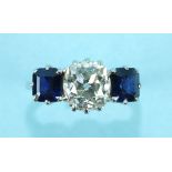 A sapphire and diamond three-stone ring claw-set an old brilliant-cut diamond between two emerald-