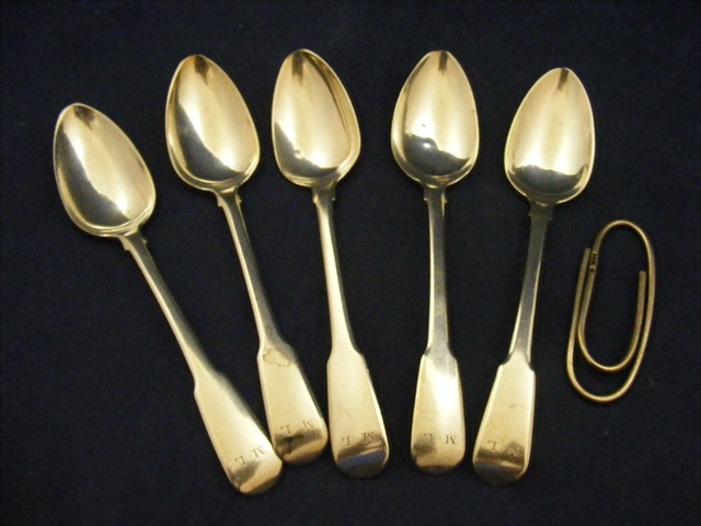 Five silver tea spoons together with a silver paperclip