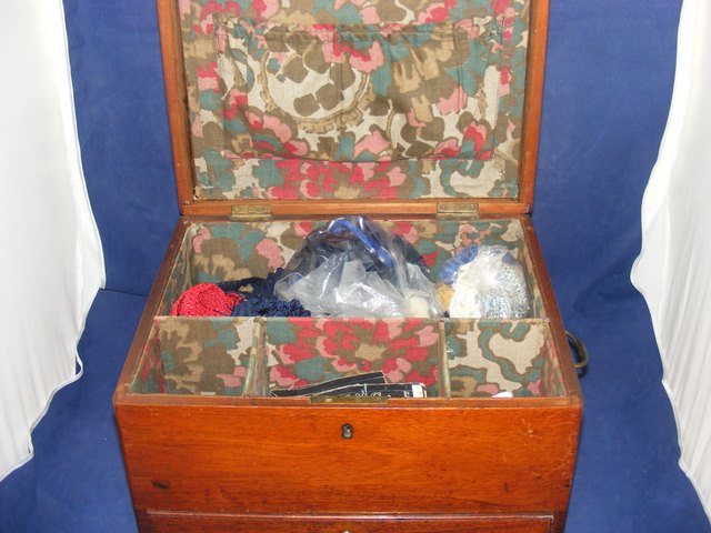 A wooden sewing box and contents